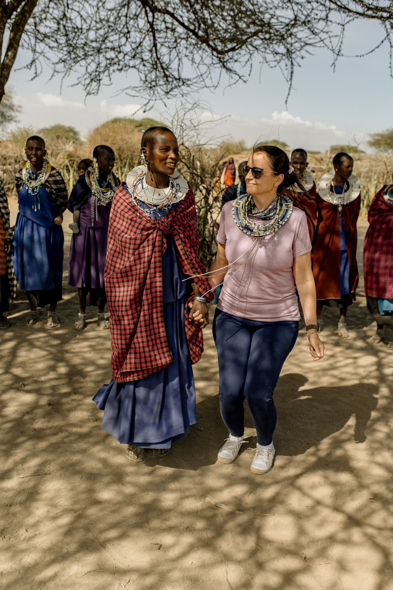 A woman is standing next to a group of women holding hands.