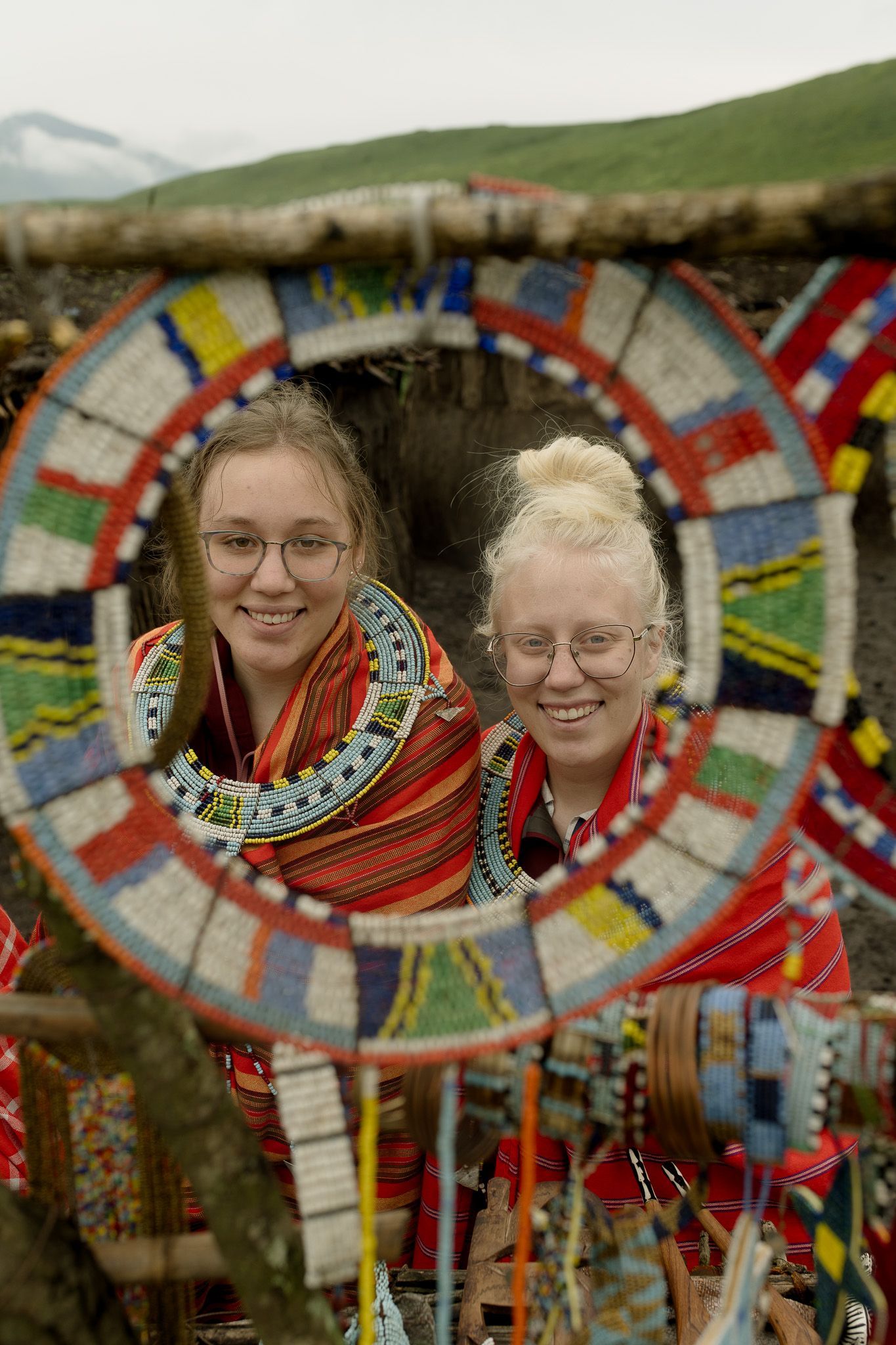 Two women are posing for a picture in front of a colorful circle.