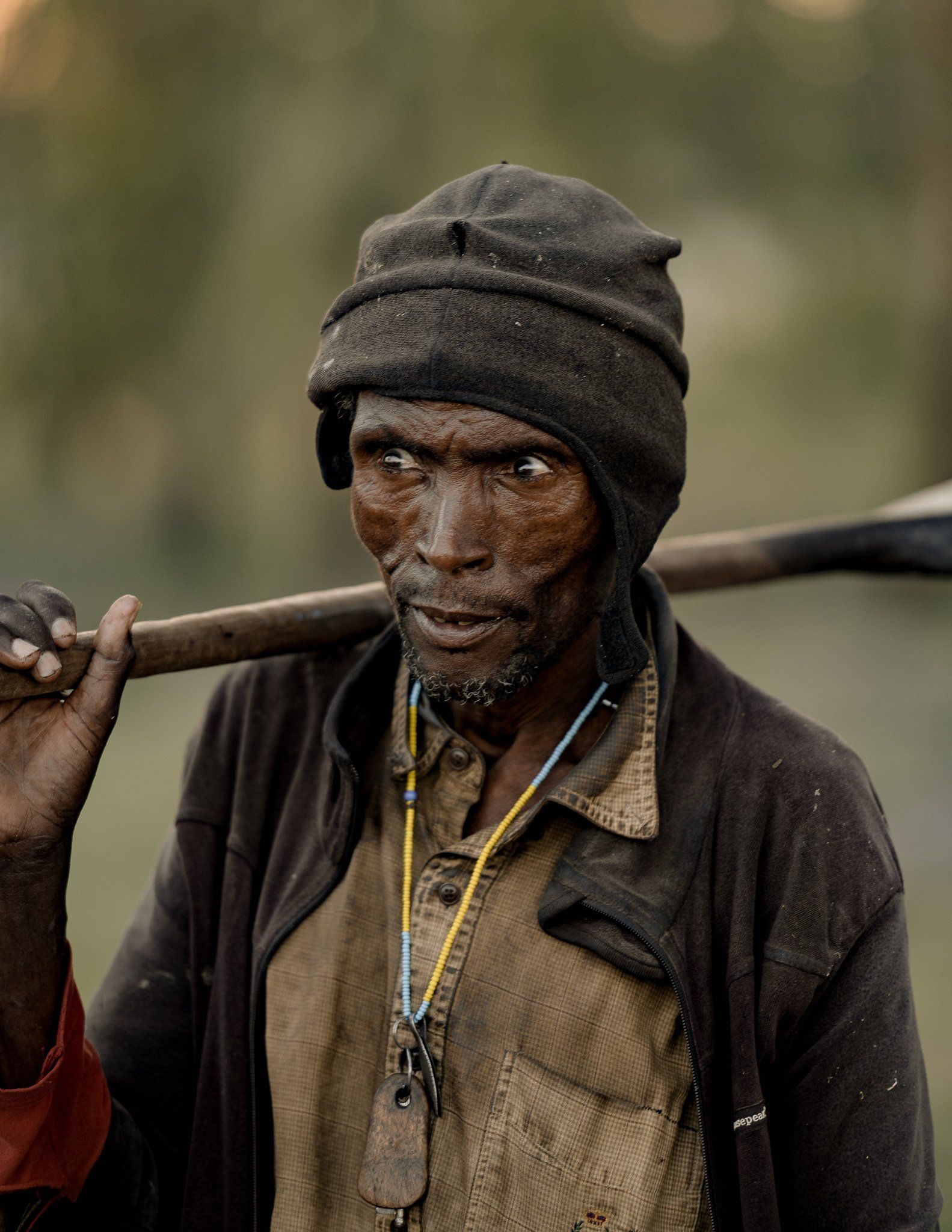 A man is carrying a stick on his shoulder.