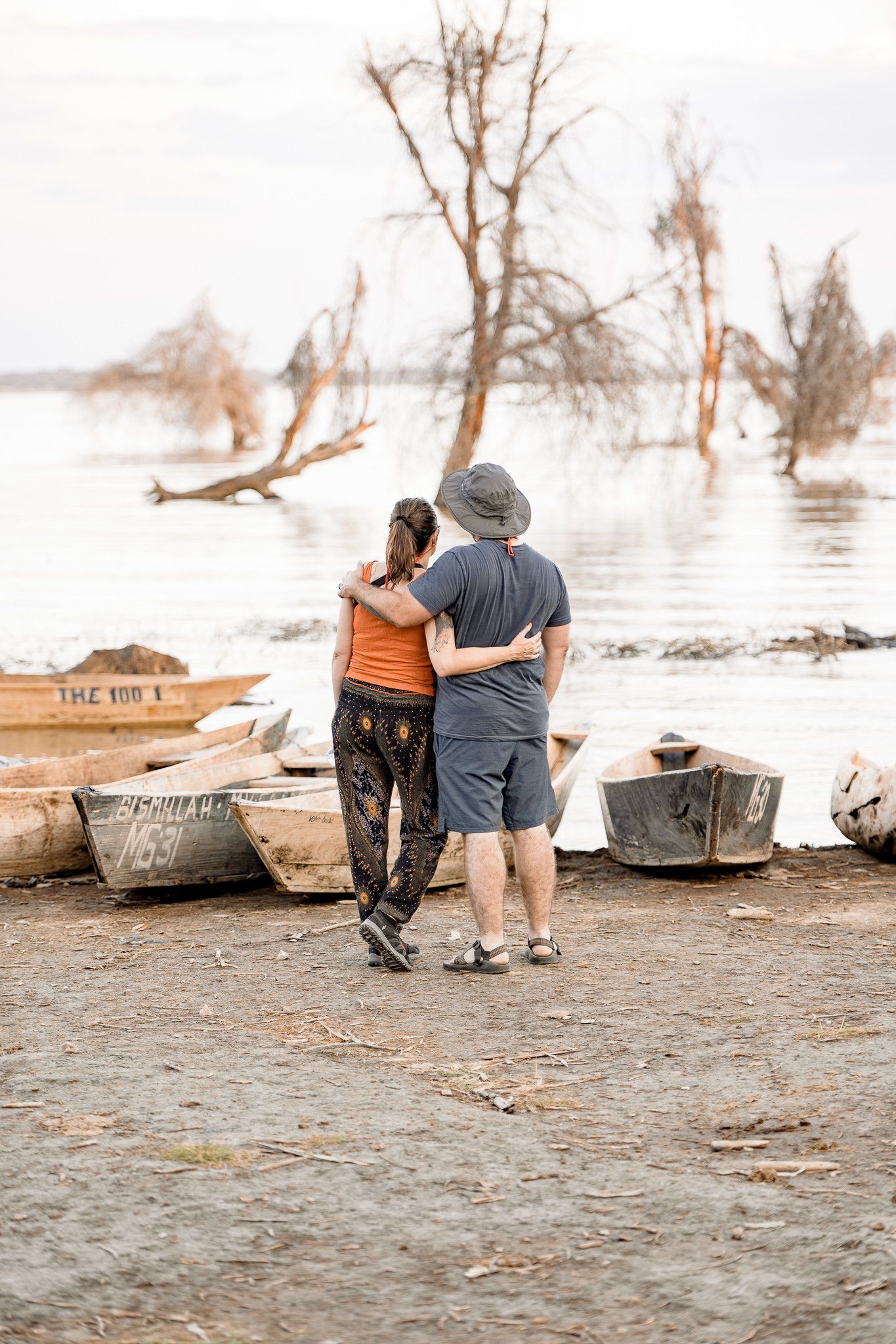 A man and a woman are hugging each other on the beach.