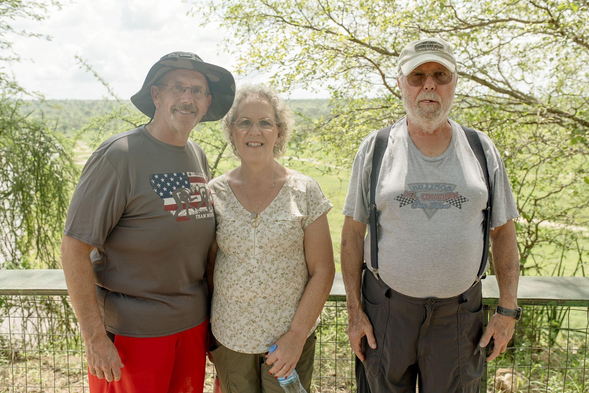Three people are posing for a picture in a field.