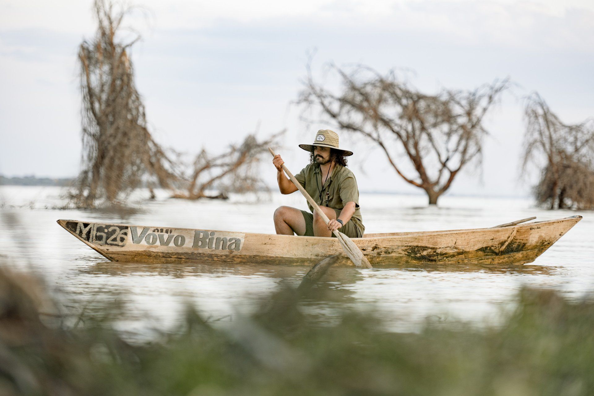 A man is rowing a boat on a lake.