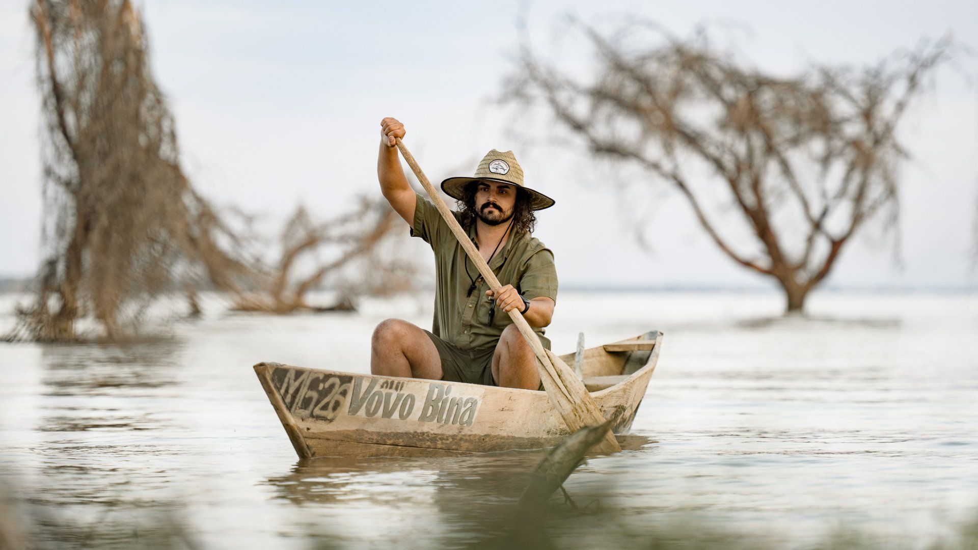 A man is rowing a boat in the water.