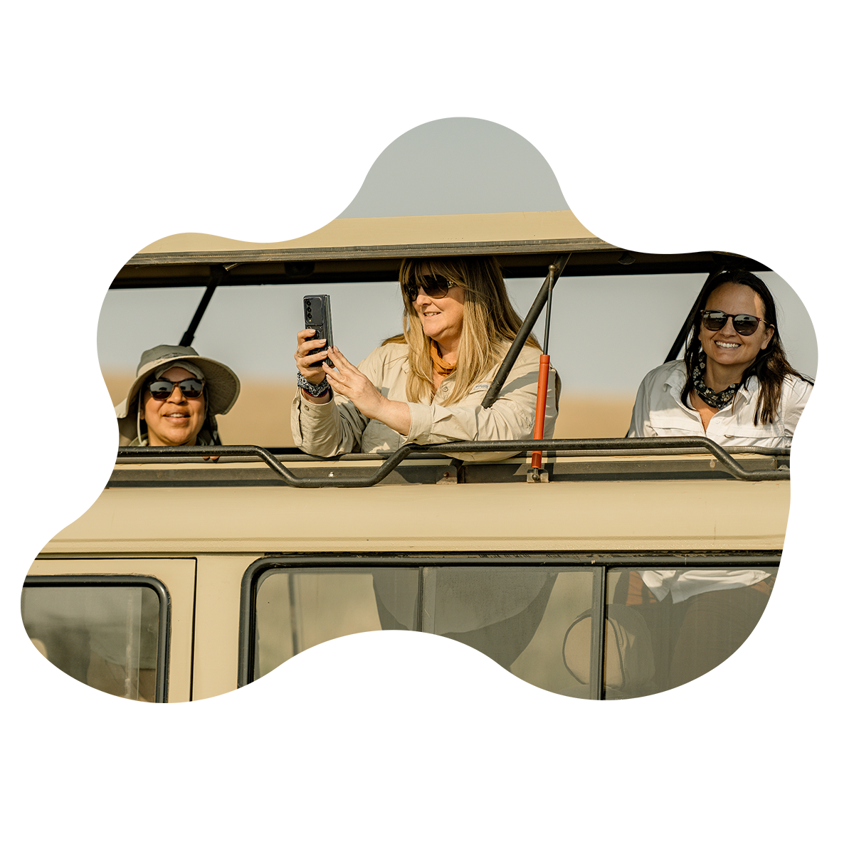 Three women are sitting in the back of a jeep looking out the window.