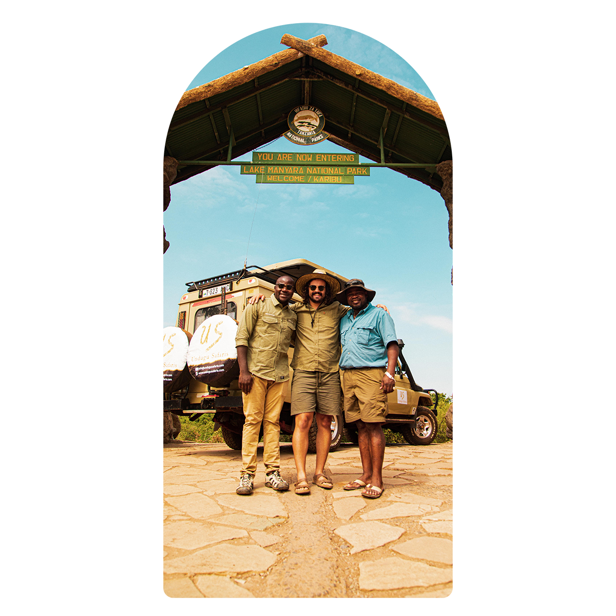 Three men are posing for a picture in front of a sign that says africa lodge