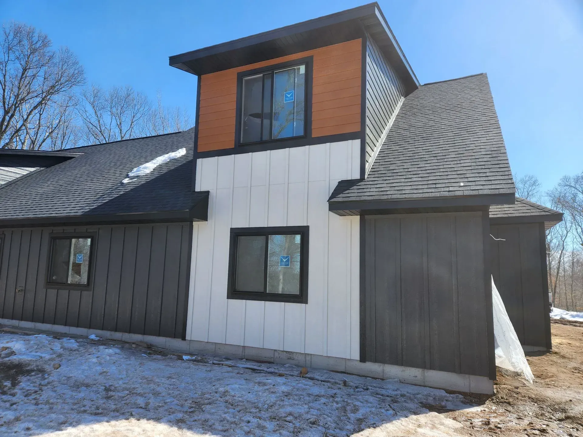 A house with a black roof and a lot of windows