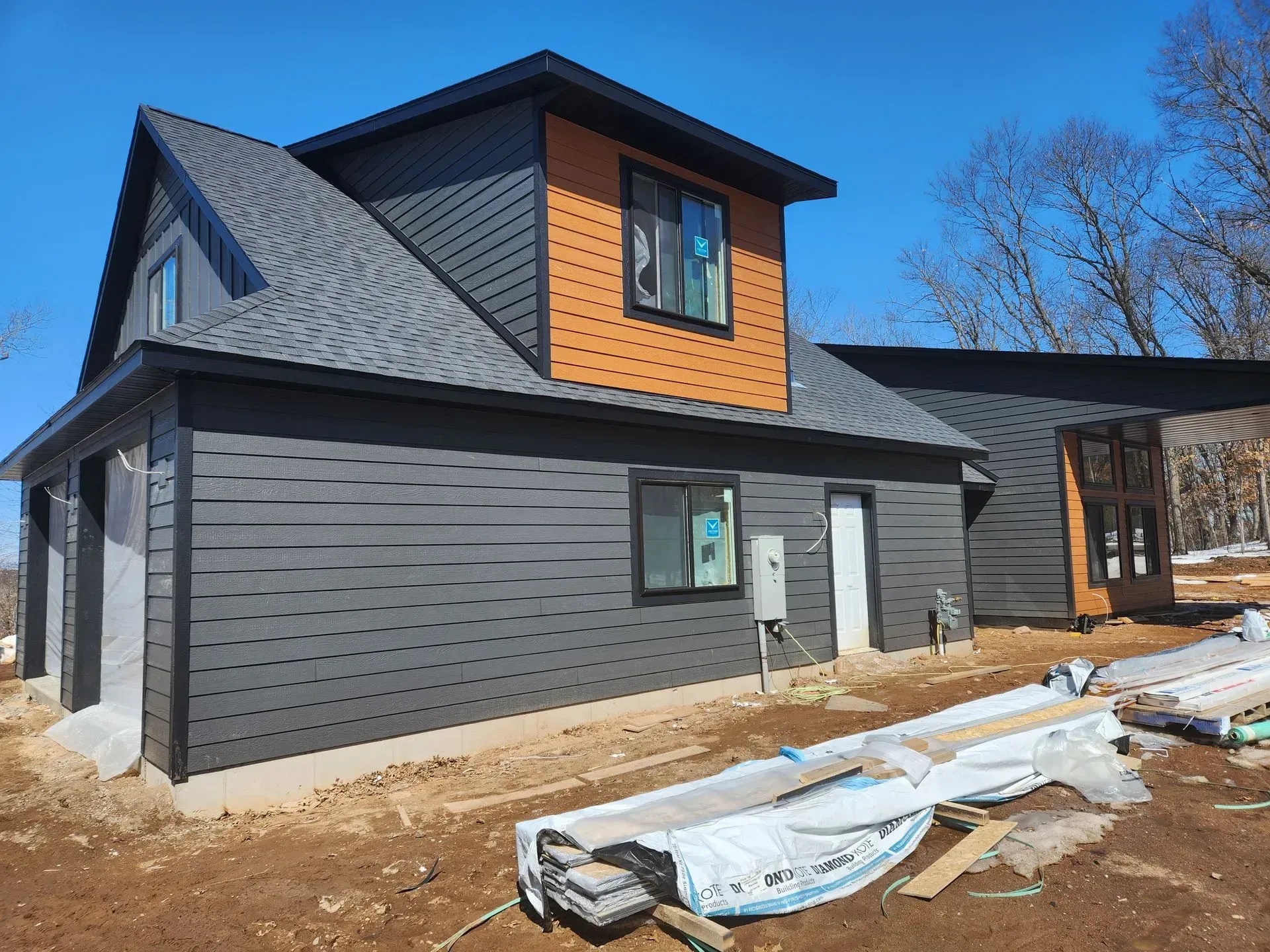 A house is being built in the middle of a dirt field.