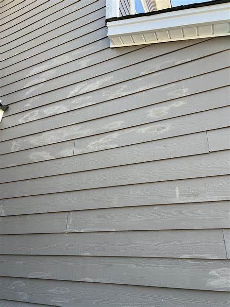 A close up of a siding on a house with a window.