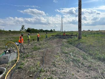 A group of construction workers are working in a field.