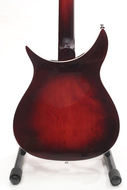 A red guitar is sitting on a stand on a white background.