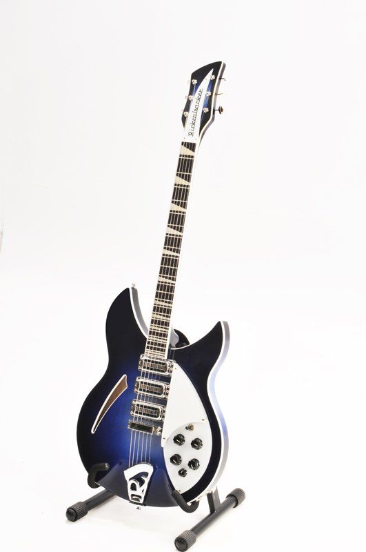 A blue and white electric guitar is sitting on a stand.