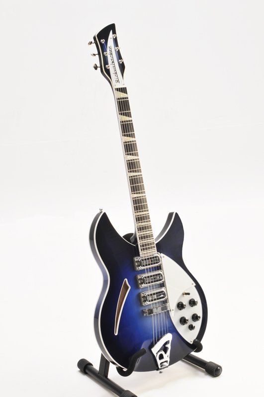A blue and white electric guitar is sitting on a stand.