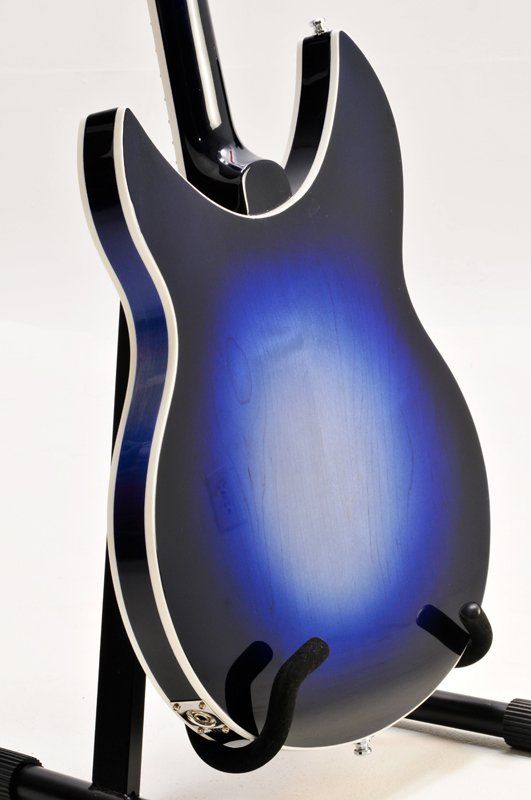 A blue and black guitar is sitting on a stand