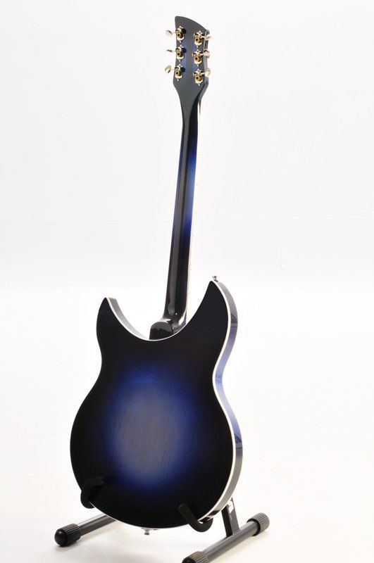 A blue electric guitar is sitting on a stand on a white background.