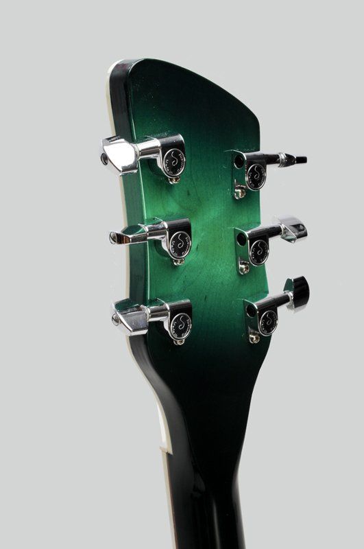 A close up of the headstock of a green guitar