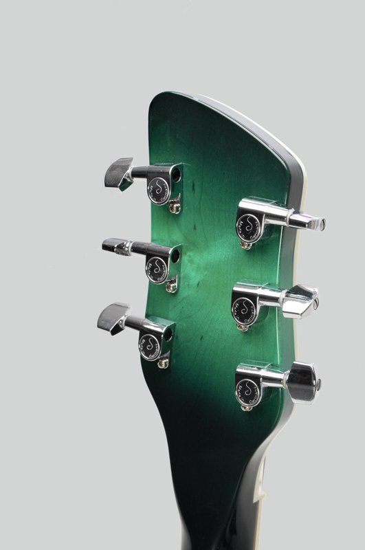 A close up of a green guitar headstock on a white background.
