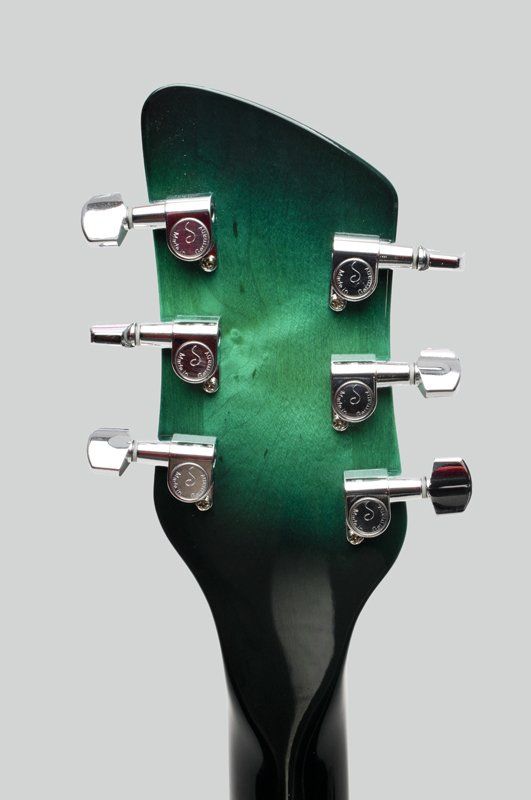 A green and black guitar headstock with chrome tuners