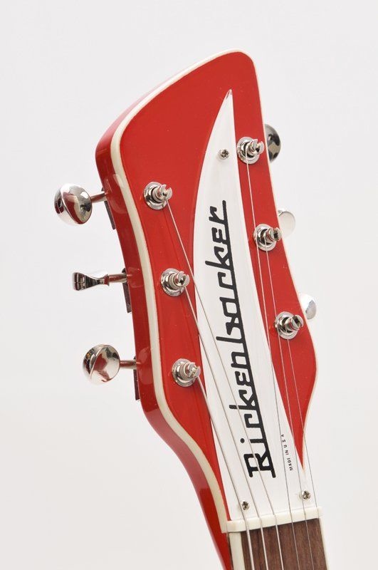 The headstock of a red rickenbacker electric guitar