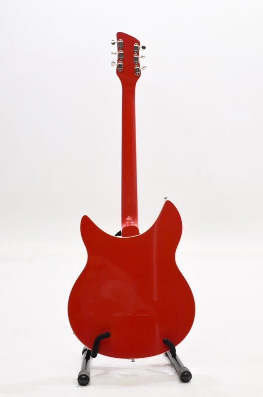 A red electric guitar is sitting on a stand on a white background.