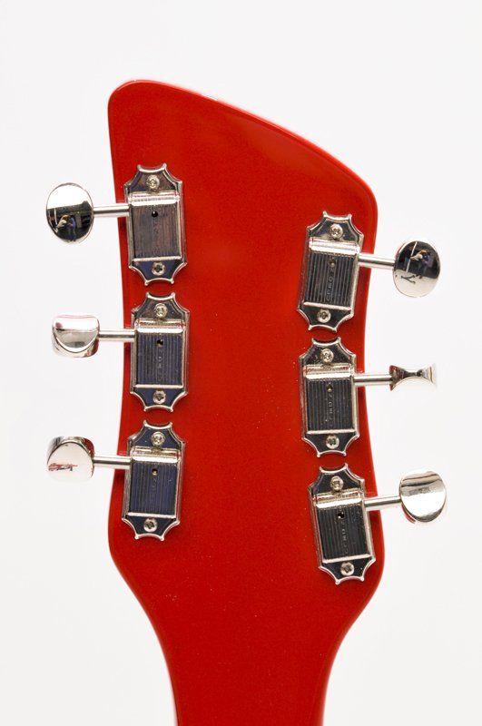 A close up of the headstock of a red guitar