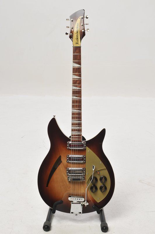 A rickenbacker guitar is sitting on a stand