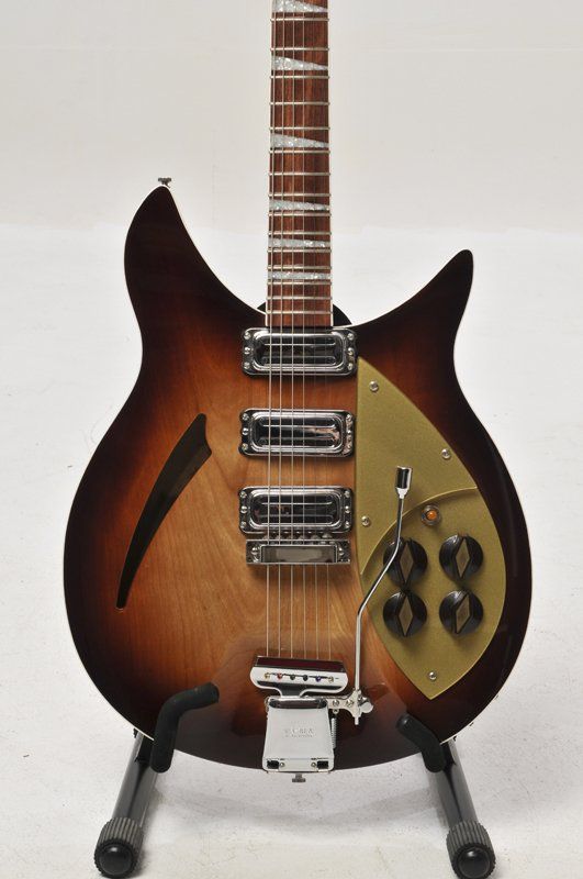 A brown electric guitar is sitting on a stand