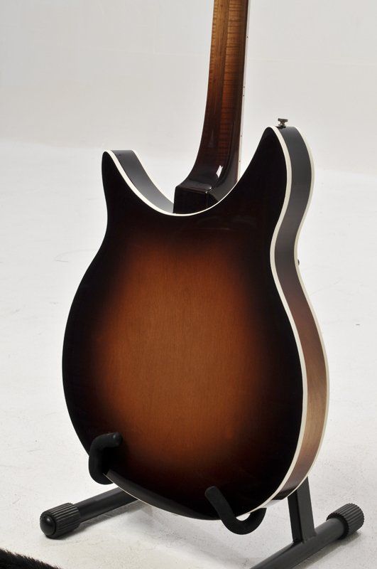 The back of a guitar is shown on a stand