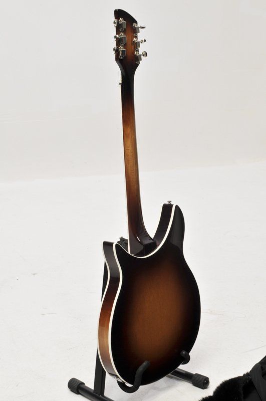 A guitar is sitting on a stand on a white surface