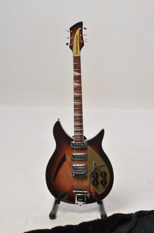 A rickenbacker guitar is sitting on a stand