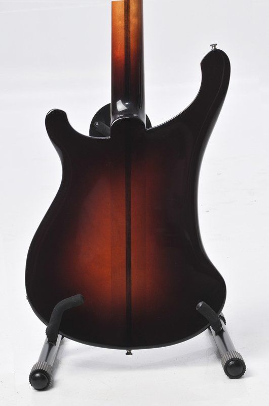 The back of a guitar is shown on a stand