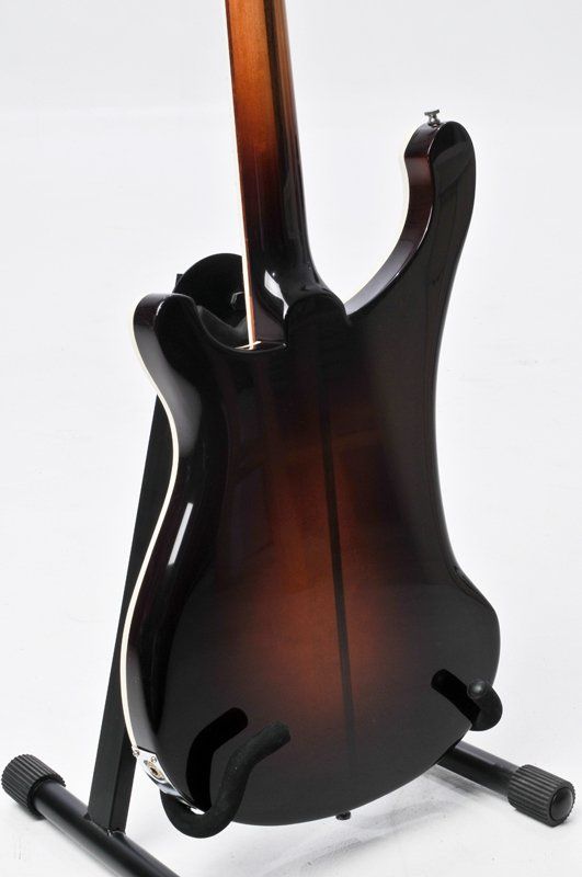 The back of a guitar is shown on a stand