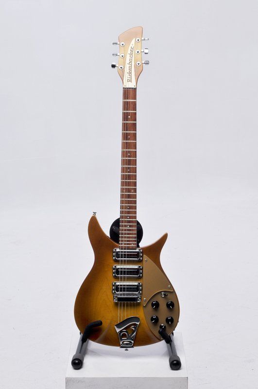 A guitar is sitting on a stand on a white background.