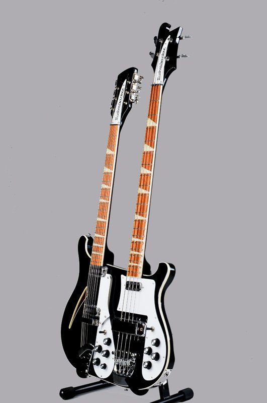 Two guitars are sitting on top of each other on a stand.