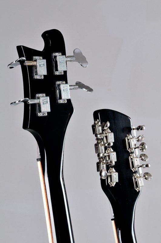 A close up of a guitar headstock on a gray background