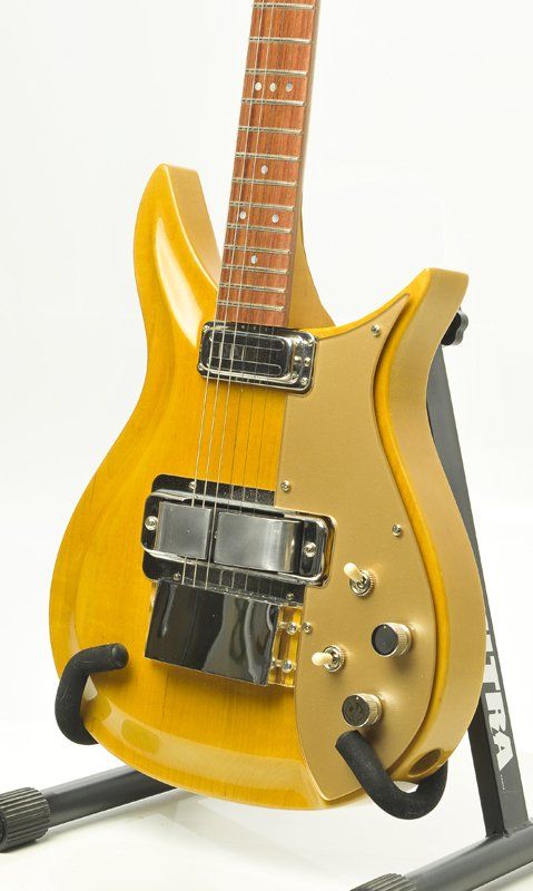 A yellow electric guitar is sitting on a stand