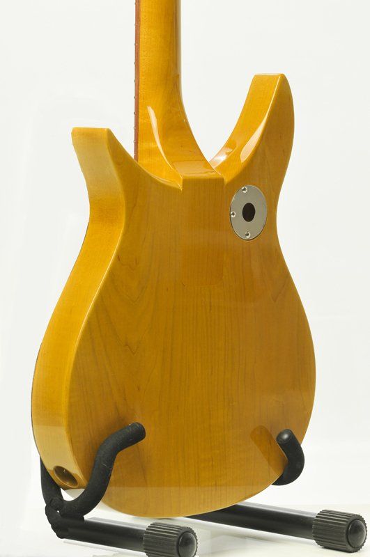 A yellow guitar is sitting on a black stand