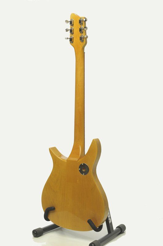 A guitar is sitting on a stand on a white background.