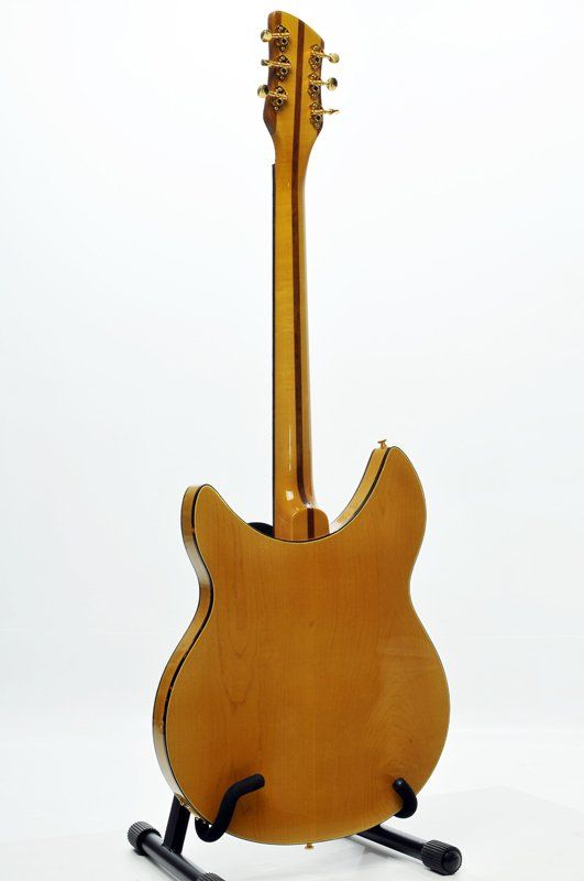A guitar is sitting on a stand on a white background.