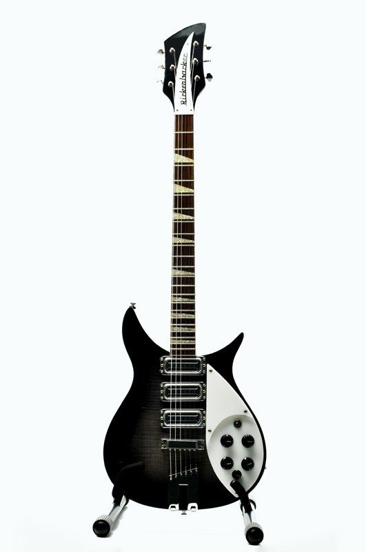 A black and white electric guitar is sitting on a stand on a white background.