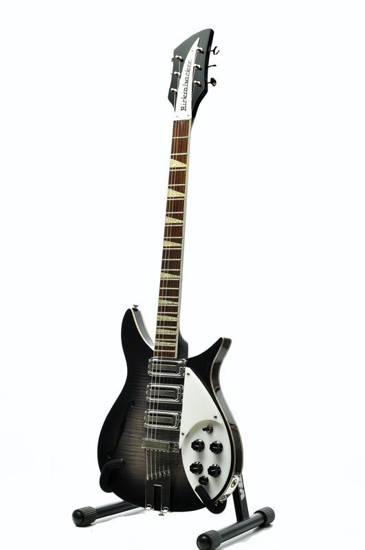 A black and white electric guitar is sitting on a stand.