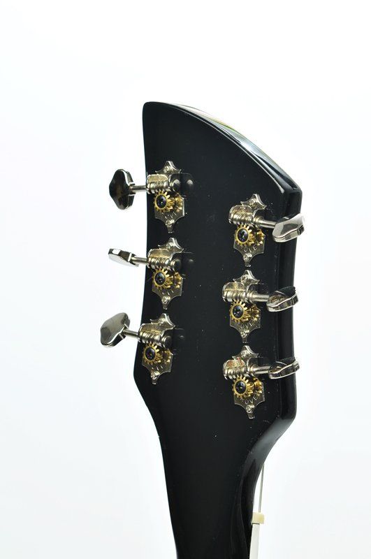 A close up of the headstock of a guitar on a white background.
