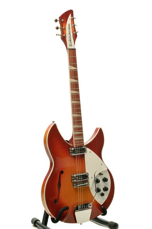 A rickenbacker guitar is sitting on a stand on a white background