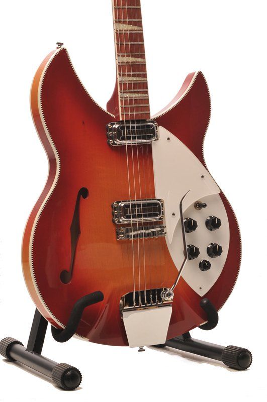 A guitar is sitting on a stand on a white background