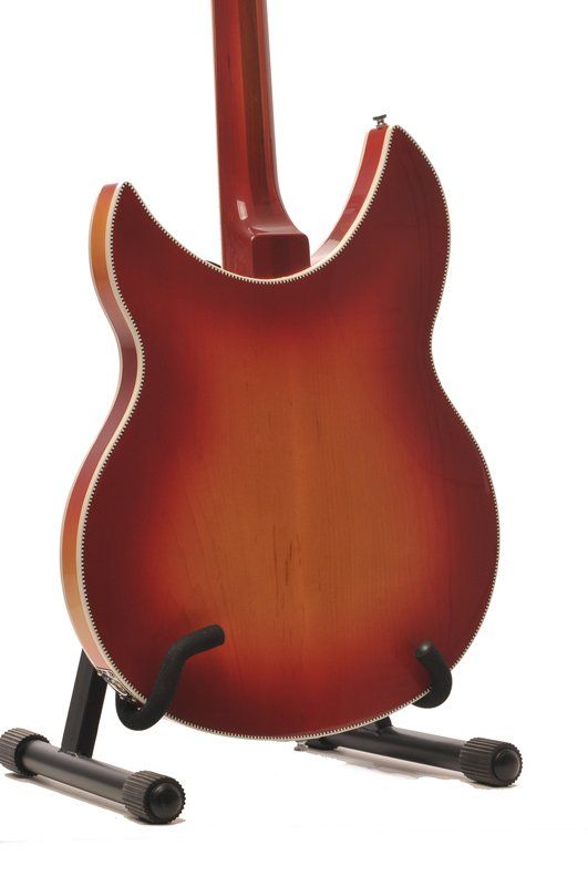 A red guitar is sitting on a stand on a white background