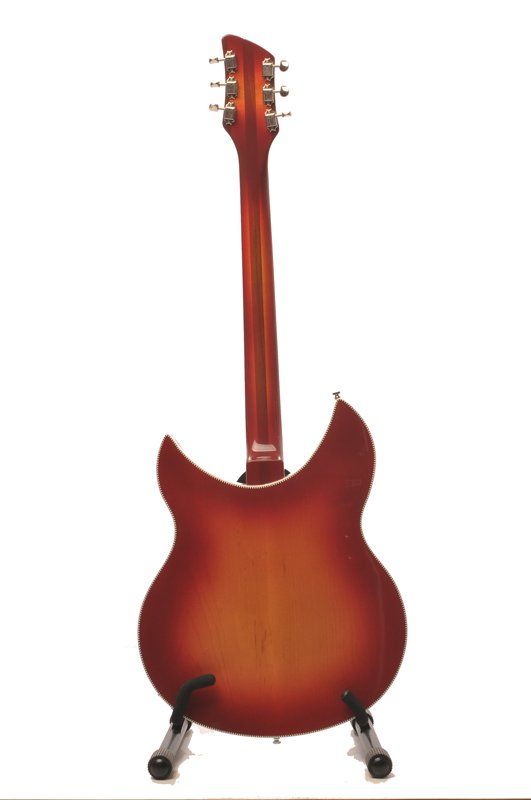 A guitar is sitting on a stand on a white background.