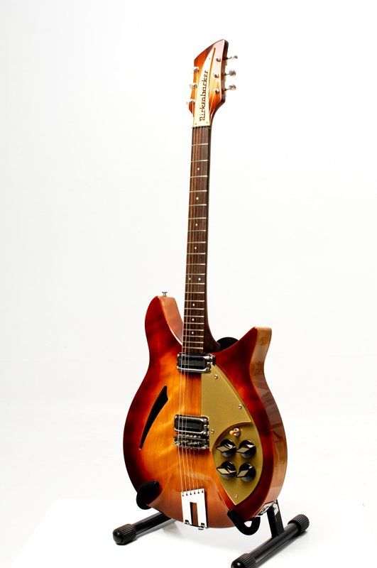 A guitar is sitting on a stand on a white background.