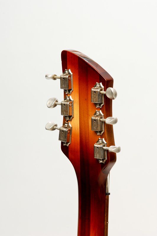 A close up of a guitar headstock on a white background.