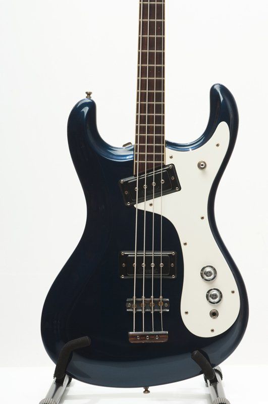 A blue and white electric bass guitar on a stand