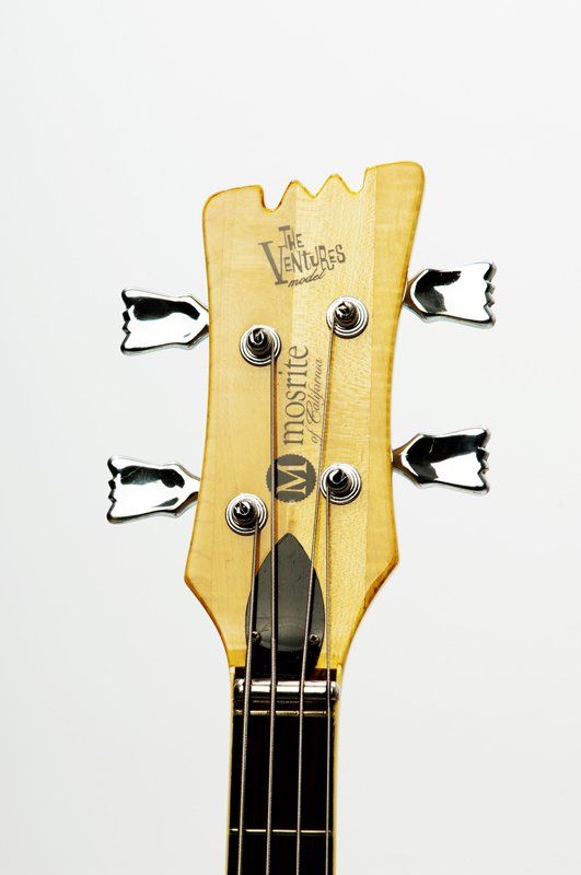 A close up of the headstock of a bass guitar