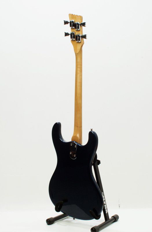 A black electric guitar is sitting on a stand